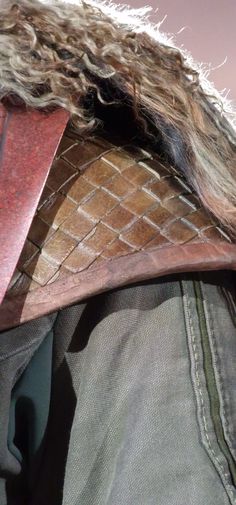 a close up of a person's head with a fur and leather mask on