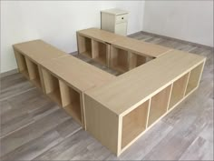 an empty room with wooden shelves and cupboards on the floor in front of a white wall