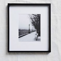 a black and white photo hanging on a wall next to a lamppost in the snow