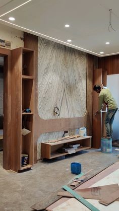 a man standing on top of a blue bucket in a room filled with wood planks