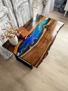 a wooden table with an artistic design on the top and blue water painted on it