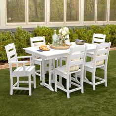 a white table and chairs sitting in the grass