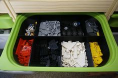 legos are arranged in a green bin on the floor