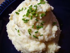 mashed potatoes on a blue plate with green chives sprinkled on top