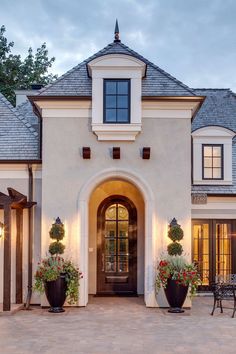 the front entrance of a house with potted plants