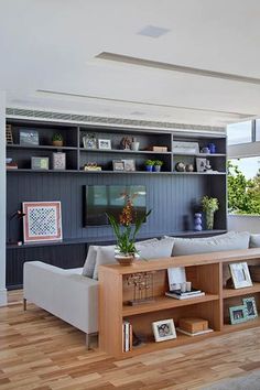 a living room filled with furniture and a flat screen tv mounted on a wall next to a wooden floor