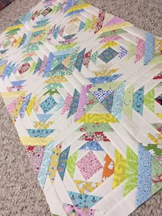 the quilts are laid out on the floor to be used as a table runner