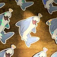 several shark stickers sitting on top of a wooden table