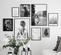 black and white photographs hang on the wall above a couch in a living room with a coffee table