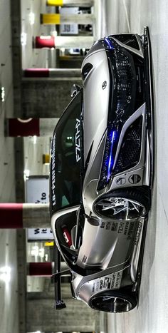 an aerial view of a car parked in a parking garage with its hood up and lights on