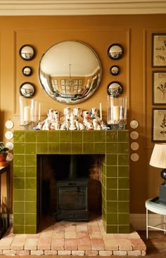 a living room filled with furniture and a fire place under a mirror on the wall