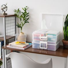 the desk is organized with plastic containers and plants