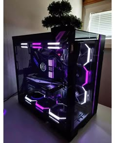 a computer case sitting on top of a table next to a plant in a window