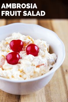 a white bowl filled with fruit salad on top of a wooden table