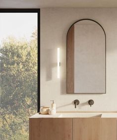 a bathroom with a sink, mirror and large window in it's side wall