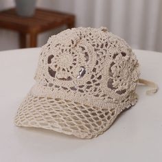 a crocheted hat sitting on top of a white table next to a wooden chair