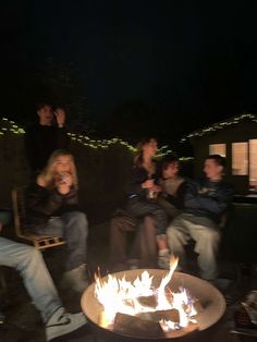 a group of people sitting around a fire pit