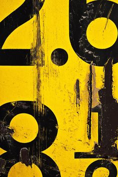 an old yellow and black sign with numbers on it