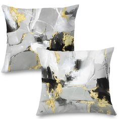 two black and white decorative pillows with gold leaf designs on the front one is square