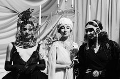 three women dressed up in costumes with birdcages on their heads