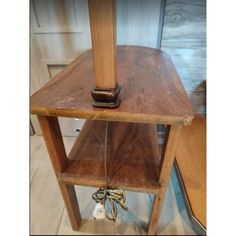 a wooden shelf with a cell phone on it and a cord attached to the top