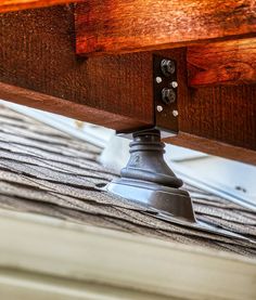 a close up view of the bottom part of a wooden bench with metal hardware on it