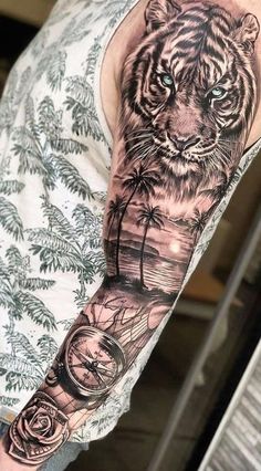 a man's arm with a tiger and palm tree tattoo on the left sleeve