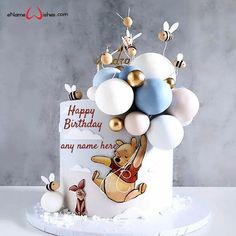 a winnie the pooh birthday cake with balloons