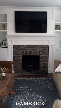 a living room with a couch, fireplace and television on the wall in front of it