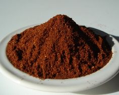 a white bowl filled with brown powder on top of a table