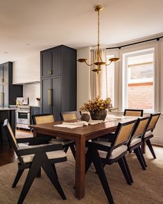 a dining room table with chairs and a potted plant on top of the table