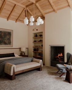 a bedroom with a bed, chair and fireplace