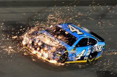 a blue and yellow race car with sparks coming out of it's back end