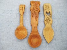 three wooden spoons with designs on them