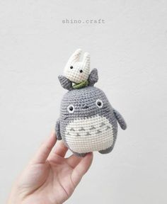 a hand holding a crocheted stuffed animal in the shape of a hippo