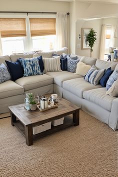 a living room filled with lots of furniture and pillows on top of a rug next to a coffee table