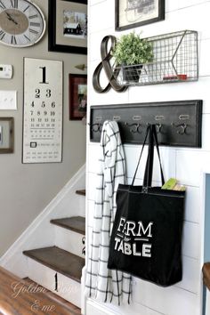 a black and white bag hanging on the wall next to some shelves with clocks above it