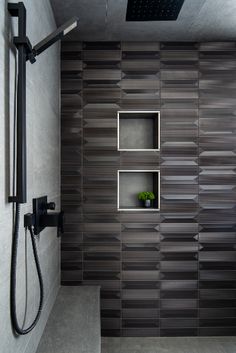 the shower head is mounted on the wall next to the shelf with a plant in it