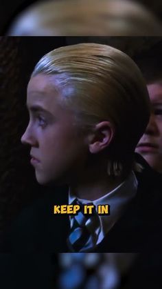 a woman with blonde hair wearing a neck tie and looking off to the side in a dark room