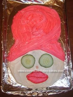 a cake that looks like a woman's face with cucumbers on it