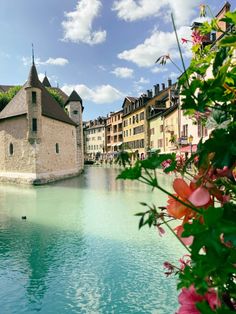 a river running through a small town next to tall buildings on the side of it