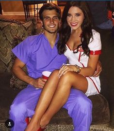 a man and woman dressed in scrubs sitting on a couch smiling at the camera