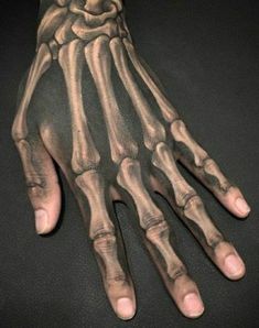 a skeleton hand tattoo on someone's left arm with the bones and hands visible