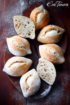 several loaves of bread on a wooden plate with powder sprinkled over them