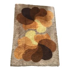 an area rug with various colors and shapes on the floor, including brown, yellow, orange