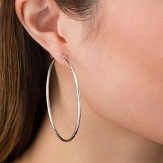 Simple and classic, these earrings are great for any daytime look. Fashioned in cool 14K white gold, these 60.0mm x 2.0mm hoop earrings are finished with a bright finish. These earrings secure comfortably with latch backs. Sleek Hoop Jewelry Gift, Sleek Hoop Jewelry As A Gift, Sleek Round Jewelry With Shiny Finish, Sleek White Gold Round Jewelry, Hypoallergenic White Gold Hoop Earrings, Sleek Sterling Silver Jewelry, Modern Hypoallergenic White Gold Hoop Earrings, Sleek Round Jewelry With Smooth Finish, Minimalist Round Hoop Earrings With Shiny Finish