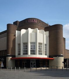 a large white building with red lettering on the front and side of it's entrance