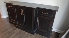 two dark wood cabinets in the corner of a room