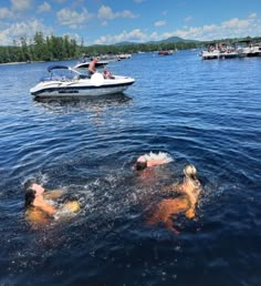 some people swimming in the water near boats