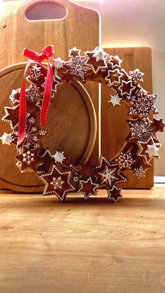 a wooden cutting board topped with a christmas wreath